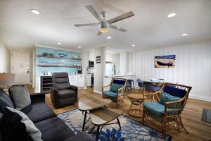 a living room with a couch and chairs and a kitchen at Seaside Cottage in Oceanside