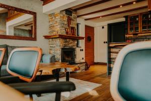 a living room with a table and a stone fireplace at Chiplakova cottage by MRS in Berovo