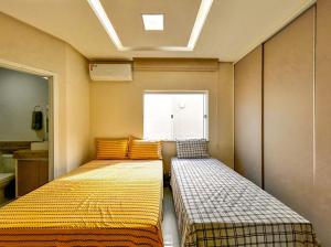 Duas camas num pequeno quarto com uma janela em Casa com lazer proxima da Praia do Mosqueiro SE em Aracaju