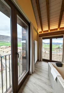 a room with a balcony with sliding glass doors at Hotel Rural Milaleku 