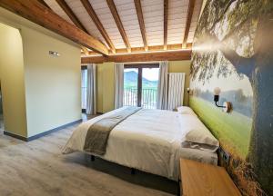 a bedroom with a bed with a painting on the wall at Hotel Rural Milaleku 