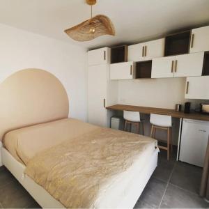 a bedroom with a bed and a desk and a table at La Tiny de Louis, au milieu des oliviers, avec jolie piscine in Draguignan