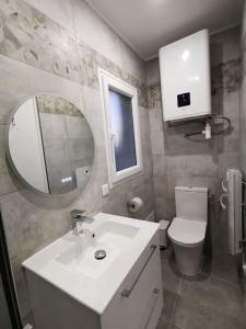 a bathroom with a sink and a toilet and a mirror at La Tiny de Louis, au milieu des oliviers, avec jolie piscine in Draguignan