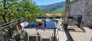 una mesa y sillas en un balcón con vistas en Guest House Vodica, en Virpazar