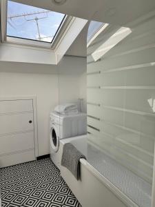 a laundry room with a washing machine and a window at Libourne - CARNOT - Centre Ville in Libourne