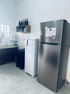 a kitchen with a stainless steel refrigerator and a freezer at Pousada Ocean Próx Sesc Bertioga - Beira Mar in Bertioga +37 photos