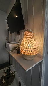 a lamp on a shelf with a television on it at Le Girod #Proche Centre#Confort in Clermont-Ferrand