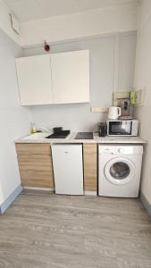 a kitchen with a washing machine and a microwave at Le Girod #Proche Centre#Confort in Clermont-Ferrand
