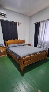 a bedroom with a wooden bed and a green floor at Vacaciones en mar y naturaleza in Bastimentos