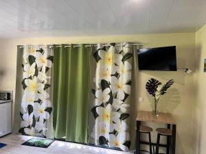 a room with a green curtain with flowers on it at Tuna House in Maroe