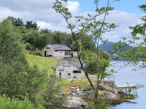 una casa su una collina vicino a un corpo d'acqua di Moderne hytte med fjordutsikt og spabad 25.min. fra Bergen sentrum a Bergen