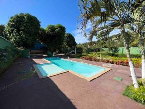 - une piscine dans une cour avec un palmier dans l'établissement Recanto do Amiguinho, à Vila Velha