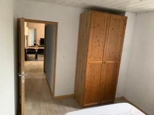 a bedroom with a wooden closet and a table at Appart 2 chambres proche rivière & centre in Saint-Ambroix
