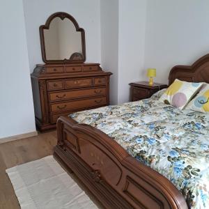 a bedroom with a bed with a dresser and a mirror at IL SOLE DI AURORA in Carasco