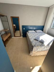 - une chambre avec un grand lit et un miroir dans l'établissement Excelente ap. 2 dorm.p/ viagens à trabalho ou lazer, à Palhoça