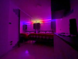una habitación con luces moradas y camas en ella en bilocale 40 mt dal mare 2 piani, en Rímini