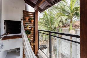 Un balcón de una casa con plantas en macetas. en Apto tranquilo a 3min da praia Canasvieiras FML202, en Florianópolis