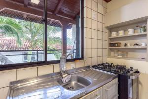 una cocina con fregadero y ventana en Apto tranquilo a 3min da praia Canasvieiras FML202, en Florianópolis