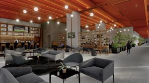 a library with couches and tables and chairs at Galeria Plaza Leon in León