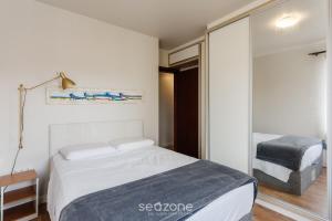 Un dormitorio con una cama y una puerta corrediza de vidrio. en Apto tranquilo a 3min da praia Canasvieiras FML202, en Florianópolis