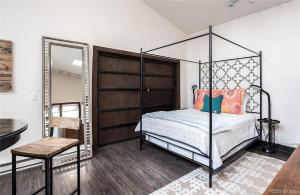 ein Schlafzimmer mit einem Himmelbett und einem Spiegel in der Unterkunft City Park Casita Walk To Eats Brews Park More in Denver