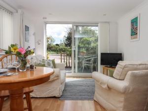 un soggiorno con un divano e un tavolo di Wisteria Cottage a Exmouth Altre 14 foto