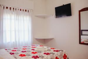 a bedroom with a bed with a flowered blanket on it at HOTEL REALICO in Realicó