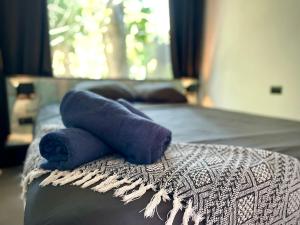 a bed with two blue towels on top of it at Casa Eden - Modern Peaceful Jungle Apartments in Cocles