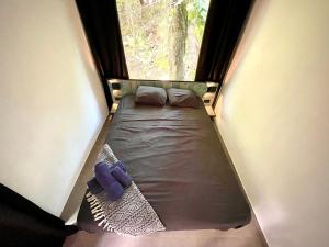 a small bed in a small room with a window at Casa Eden - Modern Peaceful Jungle Apartments in Cocles