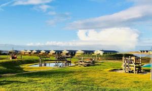 een park met een speeltuin met tafels en een waterglijbaan bij Chalet Cozy Cove te Lauwersoog in Lauwersoog