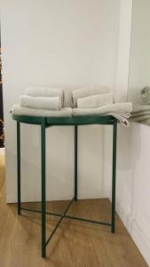 Una mesa verde con tres toallas encima. en Estúdio mobilado com cozinha na Covilhã, en Covilhã