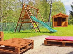 a playground with a slide and a swing set at Domki Pod Jaworem in Solina