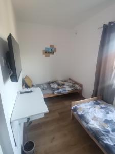 um quarto com uma cama, uma secretária e uma mesa em V&U Sobe em Brzi Brod