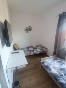 a room with a bed and a desk and a table at V&U Sobe in Brzi Brod +5 photos