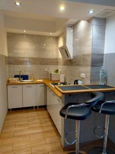 a kitchen with a counter and two stools in it at Apartament Gospodarska in Białystok