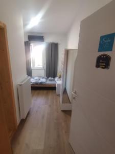 um corredor com um quarto com uma cama e uma janela em V&U Sobe em Brzi Brod