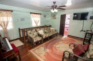 uma sala de estar com um sofá e um piano em Casa Rosa em Georgetown