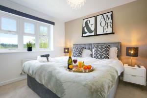 a bedroom with a bed with a tray of fruit on it at Luxury Show Home in Prime Location - Sleeps up to 6 Guests - Free Parking, Fast Wifi, SmartTV with Netflix and Private Garden by Yoko Property in Milton Keynes