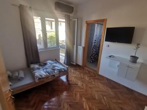 a living room with a wooden floor and a tv at V&U Sobe in Brzi Brod