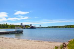 a beach with a dock in the middle of a lake at Strandbergs Stugor in Mariehamn
