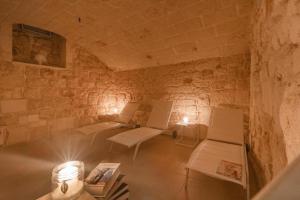 a room with benches and tables in a stone wall at Casa Sea La Vie in Ostuni