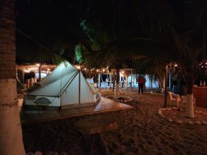 une tente assise sur la plage la nuit dans l'établissement Cabañas Paraiso Chacahua, à Chamuscadero