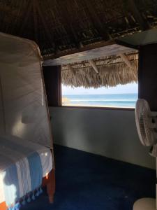 Ce lit se trouve dans un dortoir offrant une vue sur l'océan. dans l'établissement Cabañas Paraiso Chacahua, à Chamuscadero
