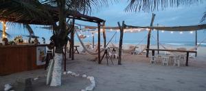 un bar de playa con mesas y sillas en la playa en Cabañas Paraiso Chacahua, en Chamuscadero