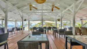 een restaurant met tafels en stoelen en plafondventilatoren bij Mount Edgecombe Boutique Hotel in Maran