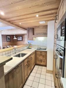 a kitchen with wooden cabinets and a sink at Résidence Aquila - 3 Pièces pour 8 Personnes 544 in Val-d'Isère