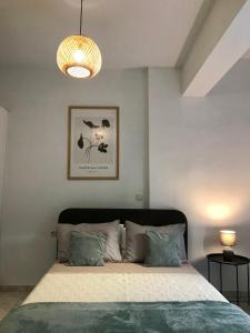 ein Schlafzimmer mit einem Bett und einer Hängeleuchte in der Unterkunft Avli House in Iraklio