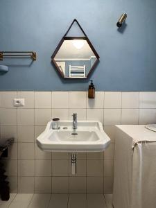 een witte wastafel in een badkamer met een spiegel bij Mini loft in Reggio Emilia