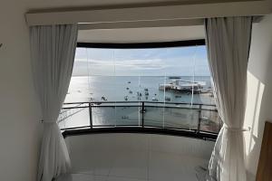 um quarto com uma varanda com vista para o oceano em Hosts BR - Flat frente mar c/ cozinha em Fortaleza