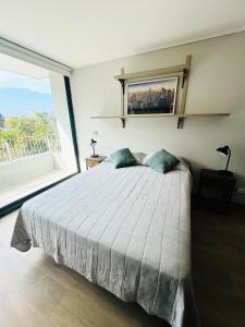 a bedroom with a large bed and a large window at Moderno departamento vanguardista en el corazón de Las Condes in Santiago
